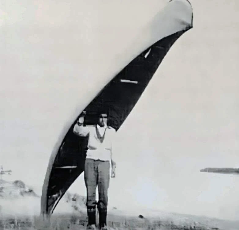 An Innu hunter carrying his canoe on a portage